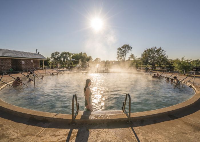A woman steps into the steaming water at the Lightning Ridge Bore Baths, Lightning Ridge