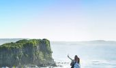 Couple taking photos on the scenic Minnamurra Headland overlooking Rangoon Island, Kiama Coast Walk in Kiama, South Coast