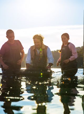 Couple enjoying a tour with Captain Sponge's Magical Oyster Tours on Pambula River, Pambula