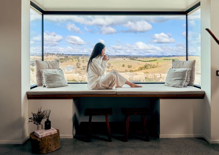 Woman enjoying coffee with a view of Wilga Station, Evans Plains